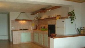 Una cocina con una isla central, armarios blancos y salpicadero de azulejos.