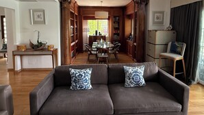 A living room with a sofa, a dining table, and a kitchen area. - Villa Pinos de Alhaurin Torre Malaga (Alhaurin de la Torre)