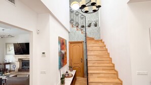 A modern interior with a wooden staircase, a dining area, and a living room with a fireplace. - Villa Pinos de Alhaurin Torre Malaga (Alhaurin de la Torre)