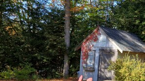 A rustic cabin with a wooden exterior and a small porch area. - Just a fishing cabin in the woods... (Portland)