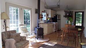 A cozy living room with a sofa, a chair, a fireplace, and a dining area with a table and chairs. - Just a fishing cabin in the woods... (Portland)