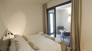 Una habitación de hotel con una cama grande, un escritorio y una silla.