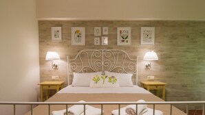 Un dormitorio ordenado con una cama, dos mesitas de noche y lámparas de pared.