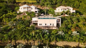 Un complexe hôtelier comprenant deux grands bâtiments, une piscine et une végétation tropicale luxuriante.