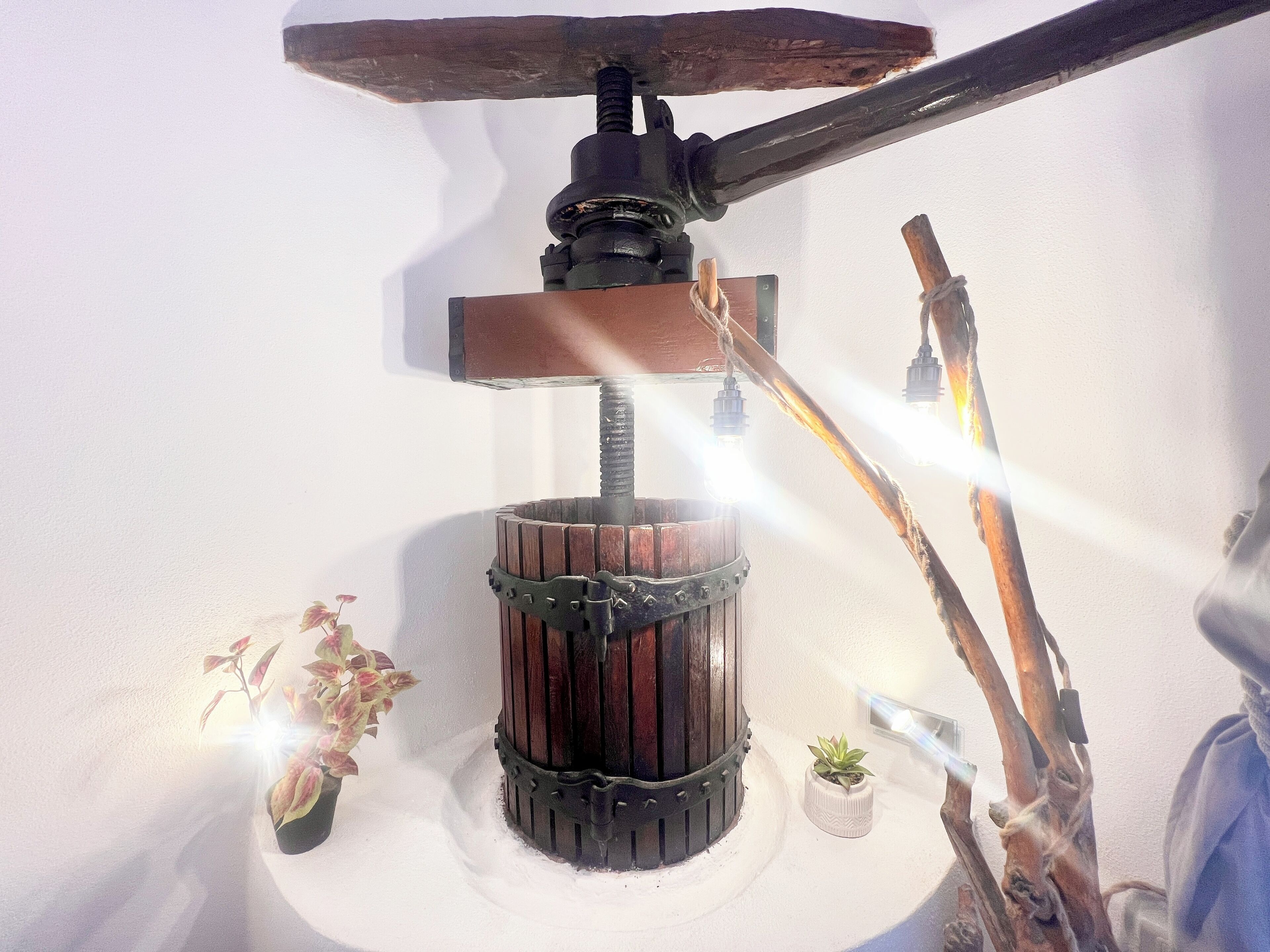 A rustic-style wall-mounted lamp with a wooden barrel base and a wooden beam above it.