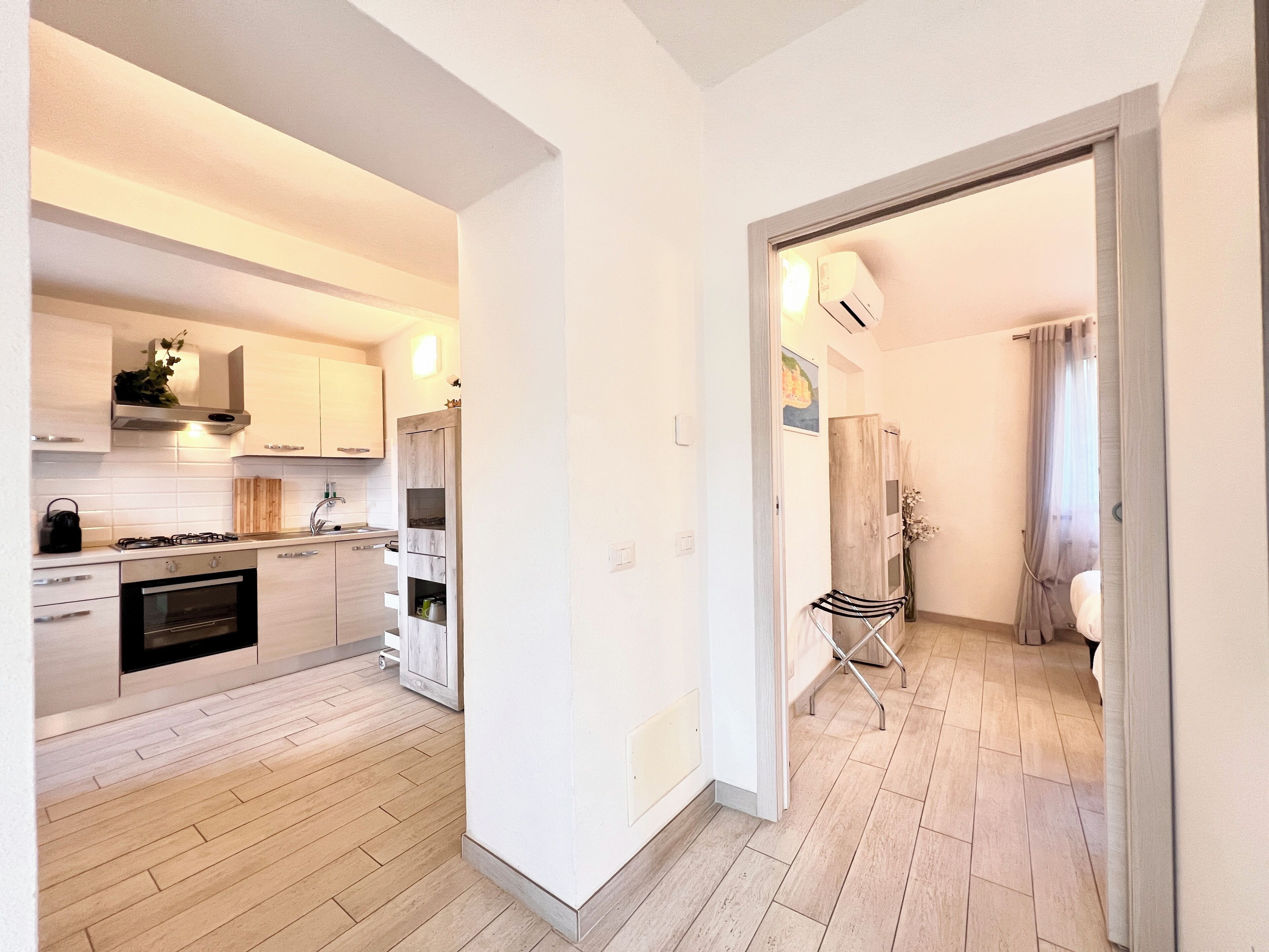 A modern kitchen with a gas stove, oven, and wooden cabinets.