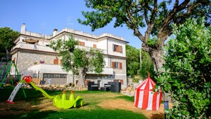 Une villa dotée d’un jardin, de mobilier d’extérieur et d’un espace de jeux.