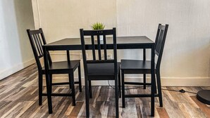 Un'area pranzo con un tavolo rettangolare e quattro sedie.