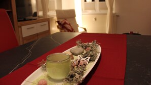 Una mesa con una bandeja que contiene una vela, un vaso de líquido y adornos decorativos.