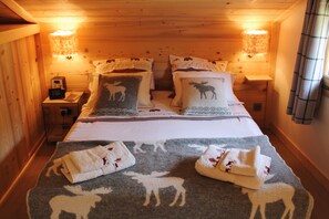 Una camera accogliente in legno con un letto, due comodini e una lampada a parete.