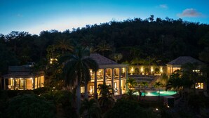 Een resort met meerdere gebouwen, een zwembad en weelderige begroeiing.