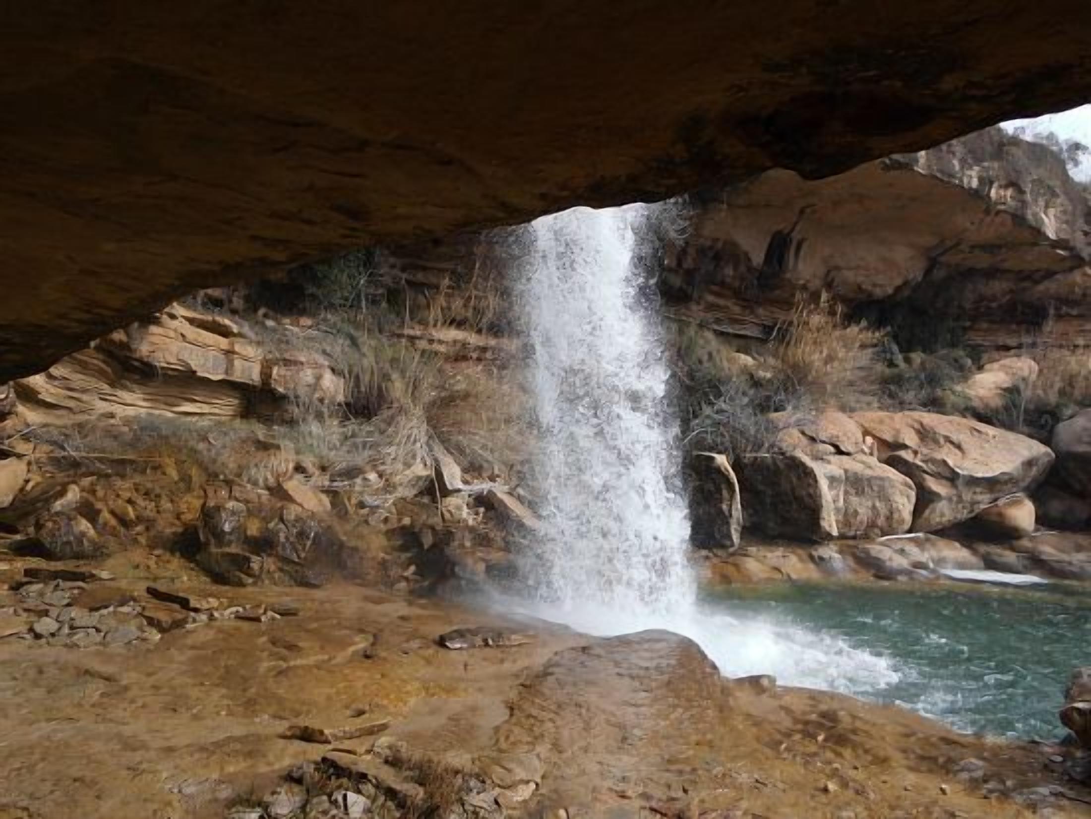 A natural rock formation with a waterfall cascading into a pool.