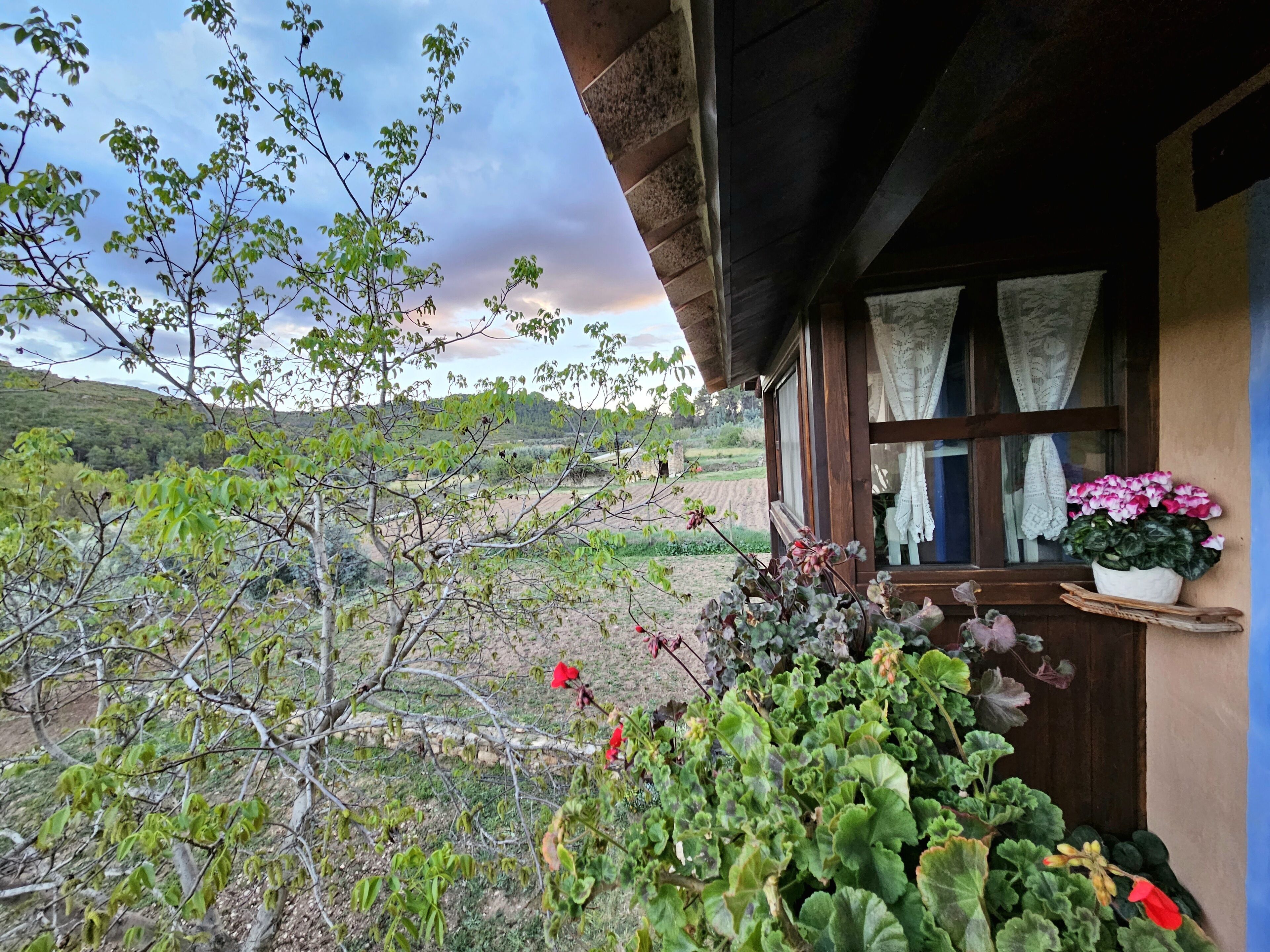 A rustic cabin with a balcony overlooking a mountainous landscape.