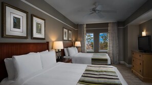 Two single beds with white linens and a flat-screen TV are featured in this stylish room.