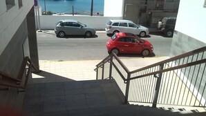 Un escalier menant à un parking où plusieurs voitures sont garées.