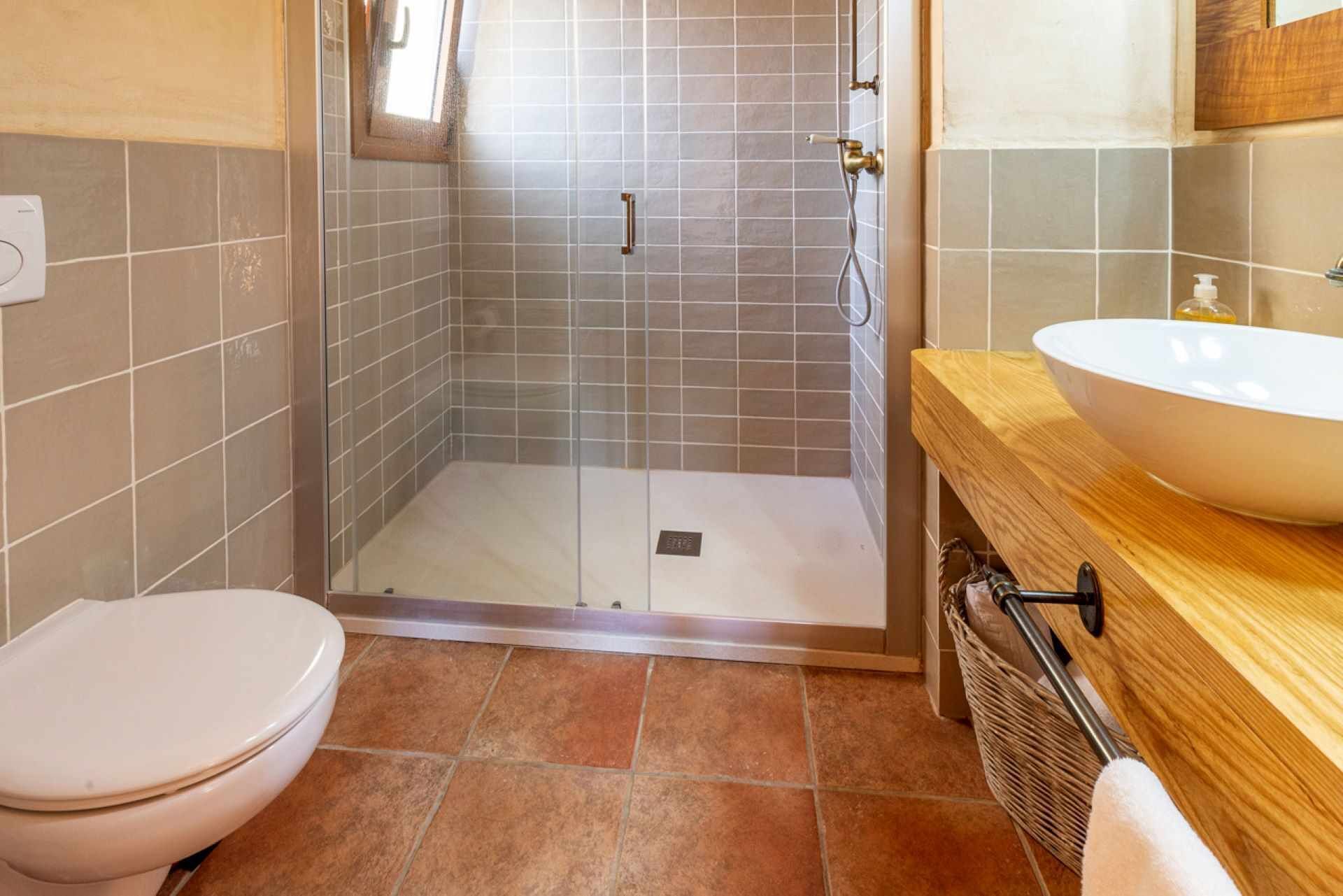 Une salle de bain avec douche, toilettes et lavabo.