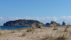 A coastal landscape with sand dunes, a rocky outcrop, and a body of water. - RURAL HOUSE IN THE COSTA BRAVA (Sant Feliu De Boada)