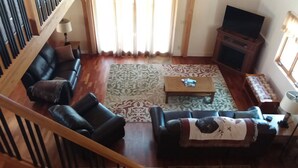 A living room with a sofa, a coffee table, and a television. - Private home on twenty wooded acres. (Plymouth)