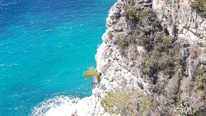 Un paysage côtier caractérisé par des eaux d’un bleu limpide et des falaises rocheuses.
