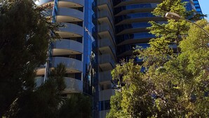 Un gratte-ciel moderne et imposant, à la conception incurvée, doté de nombreux balcons et d’une façade en verre.