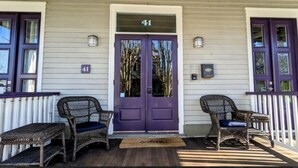 A house with a purple door, two wicker chairs, and a number 41 sign above the door. - Cozy 2 BR Apt in historic Cape May, NJ (Cape May)
