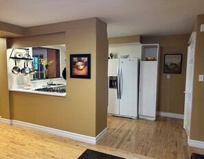 A kitchen with a stove, sink, and white refrigerator. - Spacious 2 Bedroom Mid-Downtown Apartment. Fully Furnished & Equipped. (St. John's)