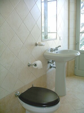 Ein Badezimmer mit Toilette, Waschbecken und einem Fenster.
