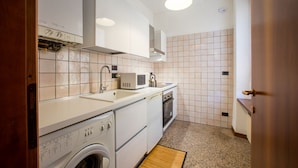 Una cocina compacta con lavadora, microondas y horno.