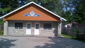 Un edificio con fachada de piedra, dos puertas con las etiquetas 3 y 4, y un cartel sobre las puertas.