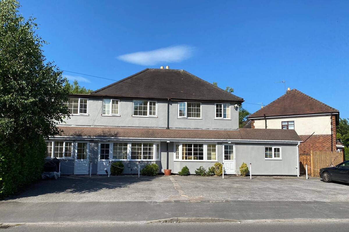 A two-story house with a garage and a driveway.