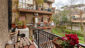 Un edificio de varios pisos con balcones, plantas en macetas y vistas a un cuerpo de agua.