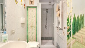 Un baño con ducha, inodoro y lavabo.