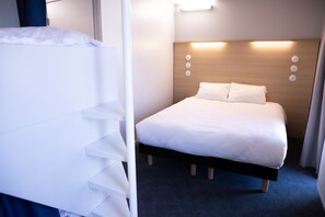 A hotel room with a bed, a bedside table, and a headboard with light fixtures. - The People Hostel - Tours (Tours)