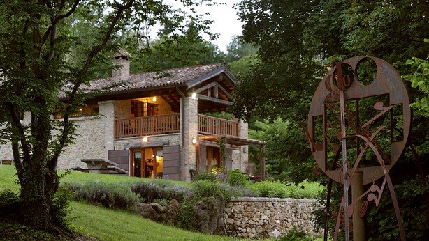 A rustic two-story house with a stone facade, wooden balcony, and a stone wall in front. - The Music Country House, between Asolo, the Prosecco hills and Monte Grappa (Castelcies)