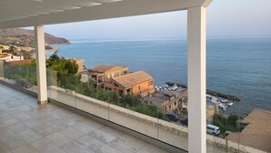 A balcony with a view of the sea and coastal buildings.