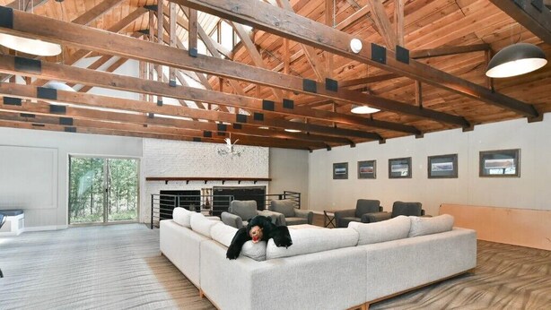 A spacious room with a large sectional sofa, wooden beams on the ceiling, and a fireplace. - Copper Moose on Main Street Awaits You!! (Breckenridge)