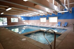An indoor swimming pool with clear water, wooden beams, and blue walls. - Copper Moose on Main Street Awaits You!! (Breckenridge)