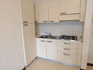 Een koelkast, kookgerei, borden en bestek