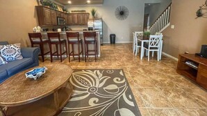 A spacious living area with a dining table and chairs, a sofa, and a coffee table. - Long Weekend | Guadalupe Riverfront | Downtown Gruene | Pool (New Braunfels)
