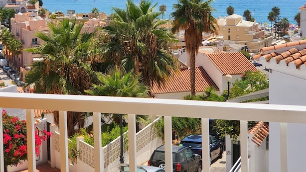 A coastal residential area with a view of the sea, palm trees, and a balcony overlooking the street. - MB Hostels Premium Eco (Nerja)