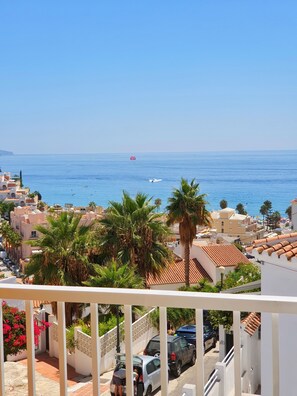 A coastal residential area with a view of the sea, palm trees, and a balcony overlooking the street. - MB Hostels Premium Eco (Nerja)