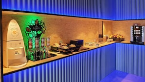 A breakfast bar with a coffee machine, a dispenser, and a fruit display. - MB Hostels Premium Eco (Nerja)