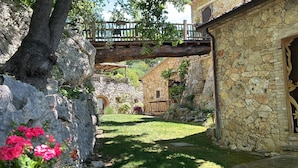 Un edificio in pietra con un ponte di legno sopra un arco in pietra.