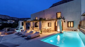 Un espace aménagé au bord de la piscine, avec des chaises longues, une table à manger et une piscine.