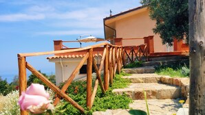 Una escalera de madera que lleva a un edificio con vistas al mar.