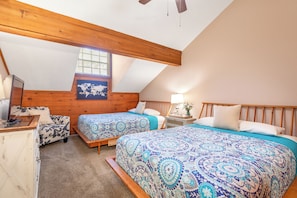 Une chambre avec deux lits, un plafond en bois, une carte du monde accrochée au mur et une petite table avec une lampe.