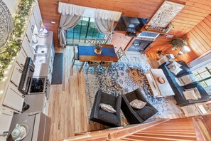 A cozy cabin interior with a dining area, kitchen, and seating space. - Cozy Ozarks Escape Near Branson ~ Perfect for Couples & Families (Branson)