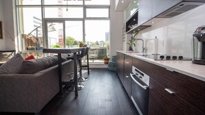 Uma cozinha moderna com área de refeições, janelas amplas e vista para a paisagem urbana.