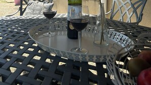 Edificio de piedra con una mesa dispuesta para una comida, que incluye una botella de vino y copas.