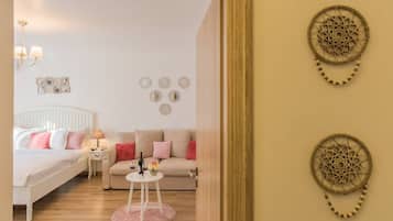 Ein Schlafzimmer mit Bett, Nachttisch, Schlafsofa, Couchtisch und Wanddekoration.